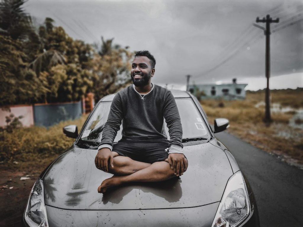 Abdullah prem sitting on top of the car